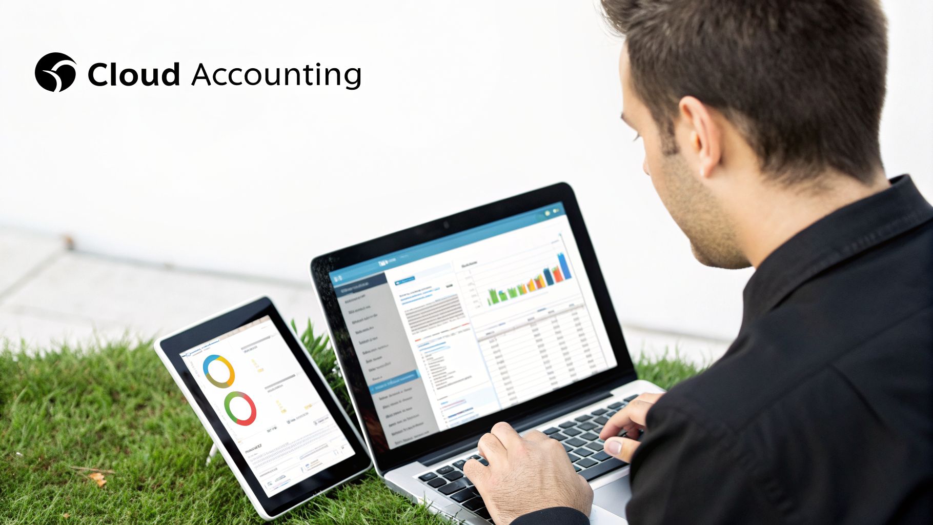 Professional using cloud accounting software on a laptop and tablet outdoors on grass.